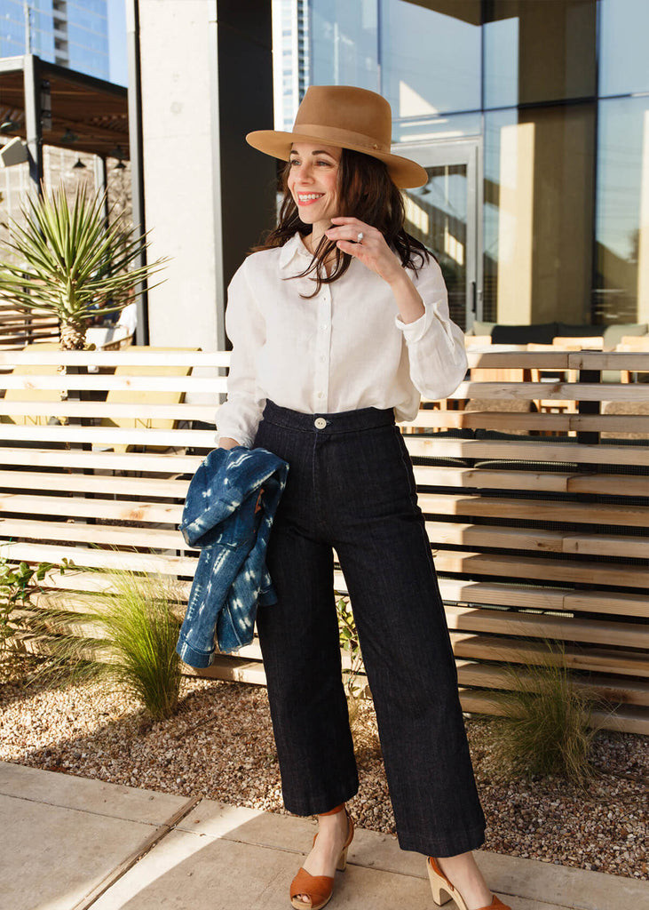 woman wearing a very dark blue wide-leg, slightly cropped pant with no pockets, and Zipper and single button front closure.